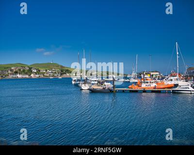 Barche a Campbeltown Marina sulla penisola di Kintyre, Scozia, Regno Unito. Preso in una giornata limpida e soleggiata con un cielo blu e senza nuvole. La barca pilota arancione ap Foto Stock