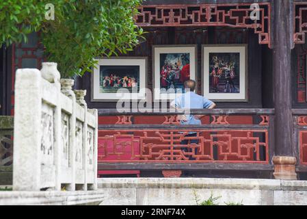 (160722) -- ANSHUN, 22 luglio 2016 -- Un visitatore guarda le mostre durante una mostra fotografica con il tema di Anshun in the Eyes of Asian Photographers in Anshun, nella provincia di Guizhou nel sud-ovest della Cina, 22 luglio 2016. Un totale di 1.200 foto sono state esposte nella mostra. ) (wyo) CHINA-GUIZHOU-ANSHUN-PHOTO EXHIBITION (CN) LiuxXu PUBLICATIONxNOTxINxCHN 160722 Anshun 22 luglio 2016 a Visitor Views Exhibitions during a Photo Exhibition with the Theme of Anshun in the Eyes of Asian Photographers in Anshun Southwest China S Guizhou Province 22 luglio 2016 un totale di 1 200 foto sono state esposte SUL mostra Foto Stock