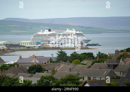 Stromness, Orcadi, Scozia, Regno Unito. 1 settembre 2023. I turisti americani che visitano le navi da crociera ormeggiate a Kirkwall visitano il cerchio di pietra neolitico Ring of Brodgar sulle Orcadi. La gente del posto ha sollevato preoccupazioni riguardo al fatto che le navi da crociera stanno portando troppi turisti nelle isole e le attuali infrastrutture non sono in grado di far fronte. PIC; navi da crociera ormeggiate al porto di Kirkwall. Iain Masterton/Alamy Live News Foto Stock