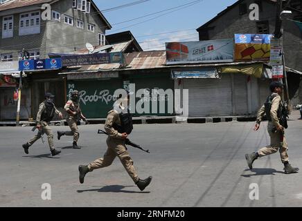 (160815) -- SRINAGAR, Aug. 15, 2016 -- Indian policemen rush to take position near the site of a gunfight in Srinagar, capital of Indian-controlled Kashmir, Aug. 15, 2016. At least seven Indian security forces personnel were injured in an attack in Indian-controlled Kashmir s capital Srinagar, a police official said on Monday. ) (wtc) KASHMIR-SRINAGAR-GUNFIGHT JavedxDar PUBLICATIONxNOTxINxCHN   160815 Srinagar Aug 15 2016 Indian Policemen Rush to Take Position Near The Site of a Gunfight in Srinagar Capital of Indian Controlled Kashmir Aug 15 2016 AT least Seven Indian Security Forces Personne Stock Photo