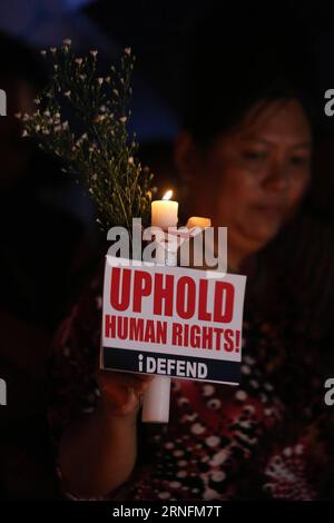 (160815) -- QUEZON CITY, Aug. 15, 2016 -- An activist holds a candle to denounce the extra-judicial killings against alleged suspects involved in illegal drugs during a protest rally in Quezon City, the Philippines, Aug. 15, 2016. The Philippine crime volume fell by 9.8 percent year-on-year in July, one month after President Rodrigo Duterte assumed office, as the latest number of the drug suspects who were killed hit 592, a senior government official said Sunday. )(hy) PHILIPPINES-QUEZON CITY-EXTRA-JUDICIAL KILLINGS-PROTEST RouellexUmali PUBLICATIONxNOTxINxCHN   160815 Quezon City Aug 15 2016 Stock Photo