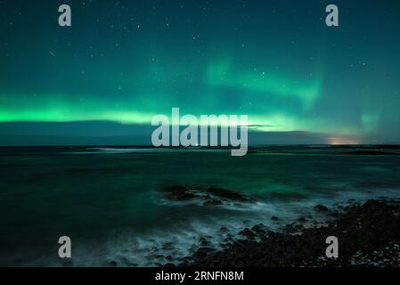 aurora boreale (aurora boreale) su una spiaggia a Hvalfjörður vicino a Reykjavik, Islanda. Foto Stock