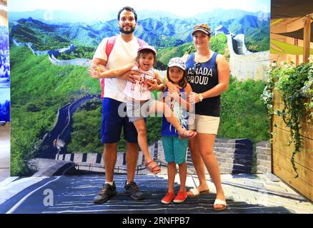 (160819)-- TORONTO, 19 agosto 2016 -- Una famiglia posa per le foto davanti a un poster della grande Muraglia fornito dall'ufficio turistico nazionale della Cina alla Canadian National Exhibition del 2016 a Toronto, Canada, 19 agosto 2016. Come una delle più grandi mostre in Canada, questo evento annuale di 18 giorni, che ha avuto inizio venerdì, dovrebbe attirare più di un milione di visitatori da tutto il mondo. ) CANADA-TORONTO-CANADIAN NATIONAL EXHIBITION ZouxZheng PUBLICATIONxNOTxINxCHN 160819 Toronto ago 19 2016 una famiglia posa per foto davanti a un poster della grande Muraglia fornito da China National Tourist o Foto Stock