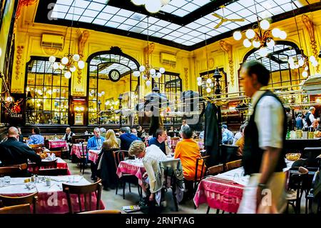 PARIGI, Francia - grande folla di persone che condividono i pasti al ristorante 'Bouillon Chartier' budget-Brasserie, nono distretto, all'interno con cameriere. Interni della brasserie parigina Foto Stock
