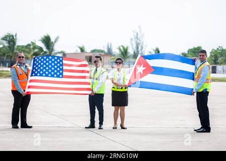 Start regulärer Linienflüge zwischen Kuba und den USA (160831) -- SANTA CLARA, Aug. 31, 2016 -- Personnel of the ground service pose for pictures with national flags of Cuba and the U.S., welcoming the first commercial flight from U.S., at the Abel Santamaria International Airport in the central Cuban city of Santa Clara, Aug. 31, 2016. The first regular direct commercial flight from the United States arrived in the central Cuban city of Santa Clara on Wednesday morning, marking an important new step in thawing ties between the former Cold War foes. ) CUBA-SANTA CLARA-U.S.-FLIGHT-RESUMPTION Li Stock Photo