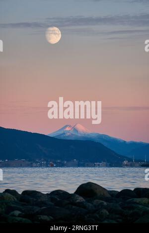 Luna che sorge su un paesaggio invernale a Godøy, Ålesund, Norvegia Foto Stock