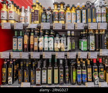 Italia - 14 agosto 2023: Olio extravergine d'oliva italiano di alta qualità in bottiglie di diversi produttori sugli scaffali in vendita in un supermar italiano Foto Stock