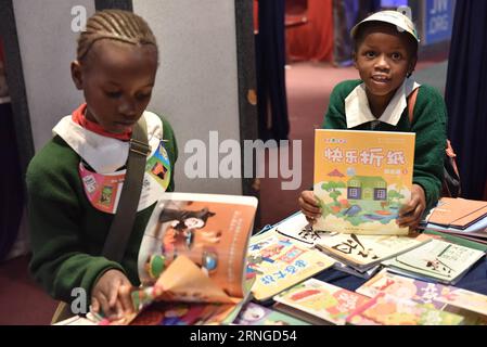 (160921) -- NAIROBI, 21 settembre 2016 -- due bambini leggono libri presso uno stand di un editore cinese durante la 19a Nairobi International Book Fair a Nairobi, Kenya, 21 settembre 2016. Essendo una delle più antiche fiere del libro dell'Africa orientale, la 19a edizione della fiera internazionale del libro di Nairobi, che si è svolta mercoledì, ha visto la partecipazione di editori provenienti da tutto il continente e dal mondo. ) KENYA-NAIROBI-BOOK FAIR SunxRuibo PUBLICATIONxNOTxINxCHN Nairobi 21 settembre 2016 due bambini leggono libri PRESSO uno stand dell'editore cinese durante la 19a Nairobi International Book Fair a Nairobi Kenya 21 settembre 2016 Foto Stock