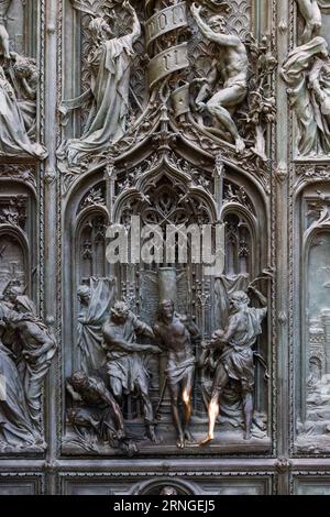 L'immagine scultorea di Gesù in bronzo sulla porta centrale del Duomo di Milano. Milano, Italia - 6 agosto 2023 Foto Stock