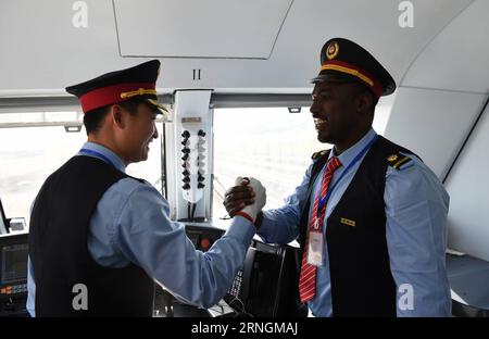 neue Eisenbahnstrecke zwischen der Hauptstadt Addis Abeba und Dschibuti (161006) -- ADDIS ABEBA, 6 ottobre 2016 -- il macchinista cinese Liu Ji (L) e il suo collega etiope Geto stringono la mano prima della cerimonia di inaugurazione della ferrovia Addis Abeba-Gibuti ad Addis Abeba, Etiopia, il 5 ottobre 2016. L'Etiopia e Gibuti hanno lanciato mercoledì la prima ferrovia moderna elettrificata dell'Africa che collega le loro capitali, con funzionari che hanno salutato la ferrovia di costruzione cinese come l'ultima testimonianza dell'amicizia sino-africana. La ferrovia Etiopia-Gibuti di 752 km, nota anche come ferrovia Addis Abeba-Gibuti, Foto Stock