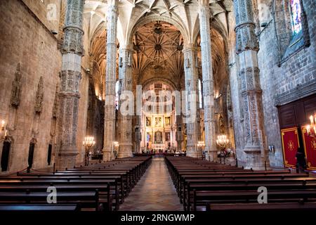 Monastero di Jeronimos nave Manueline Architecture Belem Portogallo // BELEM, Portogallo - la navata del Mosteiro dos Jeronimos (Monastero di Jeronimos) mostra l'elaborato stile architettonico manuelino che definisce questo sito patrimonio mondiale dell'UNESCO. Costruito all'inizio del XVI secolo durante l'età delle scoperte del Portogallo, il monastero presenta colonne svettanti che si diramano in intricate volte a costine sopra la testa. La struttura è stata costruita per commemorare il successo del viaggio di Vasco da Gama in India ed è stata finanziata dalla ricchezza commerciale delle esplorazioni marittime portoghesi. Re Manuele ho commissionato il mostro Foto Stock
