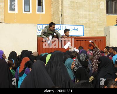 (161025) -- QAYYARAH, 25 ottobre 2016 -- le persone del campo di Jadah ricevono cibo nella città di Qayyarah nel sud di Mosul, Iraq, il 25 ottobre 2016. L'Ufficio delle Nazioni Unite per il coordinamento degli affari umanitari (OCHA) Stephane Dujarric ha detto ai giornalisti martedì che quasi 9.000 persone sono sfollate internamente a seguito dell'operazione militare di Mosul in Iraq. Lise grande, coordinatore umanitario delle Nazioni Unite per l'Iraq, ha detto che le operazioni militari per riprendere Mosul potrebbero innescare la più grande crisi umanitaria nel 2016, poiché la situazione della sicurezza nell'area limita la capacità delle agenzie di aiuto di fornire aiuto. ) IRAQ-QAYARA Foto Stock