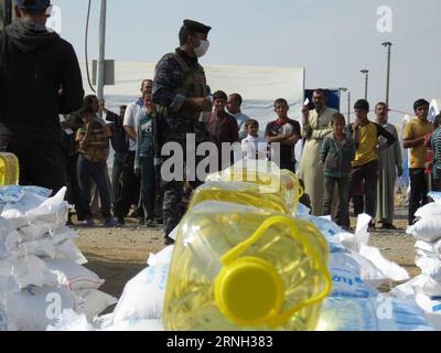 (161025) -- QAYYARAH, 25 ottobre 2016 -- le persone del campo di Jadah ricevono cibo nella città di Qayyarah nel sud di Mosul, Iraq, il 25 ottobre 2016. L'Ufficio delle Nazioni Unite per il coordinamento degli affari umanitari (OCHA) Stephane Dujarric ha detto ai giornalisti martedì che quasi 9.000 persone sono sfollate internamente a seguito dell'operazione militare di Mosul in Iraq. Lise grande, coordinatore umanitario delle Nazioni Unite per l'Iraq, ha detto che le operazioni militari per riprendere Mosul potrebbero innescare la più grande crisi umanitaria nel 2016, poiché la situazione della sicurezza nell'area limita la capacità delle agenzie di aiuto di fornire aiuto. ) IRAQ-QAYARA Foto Stock