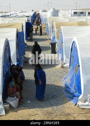 (161025) -- QAYYARAH, 25 ottobre 2016 -- le persone del campo di Jadah si trovano di fronte alle loro tende nella città di Qayyarah nel sud di Mosul, Iraq, il 25 ottobre 2016. L'Ufficio delle Nazioni Unite per il coordinamento degli affari umanitari (OCHA) Stephane Dujarric ha detto ai giornalisti martedì che quasi 9.000 persone sono sfollate internamente a seguito dell'operazione militare di Mosul in Iraq. Lise grande, coordinatore umanitario delle Nazioni Unite per l'Iraq, ha affermato che le operazioni militari per riprendere Mosul potrebbero innescare la più grande crisi umanitaria nel 2016, poiché la situazione della sicurezza nell'area limita la capacità delle agenzie di aiuto di consegnare Hel Foto Stock