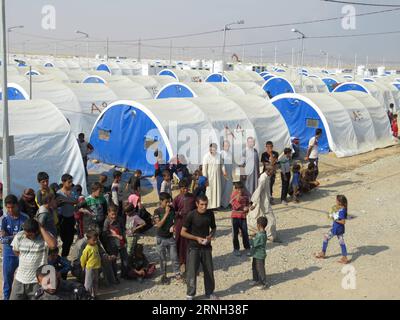 (161025) -- QAYYARAH, 25 ottobre 2016 -- le persone del campo di Jadah ricevono cibo nella città di Qayyarah nel sud di Mosul, Iraq, il 25 ottobre 2016. L'Ufficio delle Nazioni Unite per il coordinamento degli affari umanitari (OCHA) Stephane Dujarric ha detto ai giornalisti martedì che quasi 9.000 persone sono sfollate internamente a seguito dell'operazione militare di Mosul in Iraq. Lise grande, coordinatore umanitario delle Nazioni Unite per l'Iraq, ha detto che le operazioni militari per riprendere Mosul potrebbero innescare la più grande crisi umanitaria nel 2016, poiché la situazione della sicurezza nell'area limita la capacità delle agenzie di aiuto di fornire aiuto. ) IRAQ-QAYARA Foto Stock