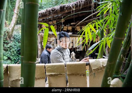 (161208) -- CHONGQING, 7 dicembre 2016 -- li Gaoqiang dries Tuhuo paper in Xinglong Town, South West China S Chongqing, 7 dicembre 2016. La famiglia li, che vive nella città di Chongqing a Xinglong, ha tramandato il tradizionale mestiere di fabbricazione della carta Tuhuo attraverso cinque generazioni. La carta tuhuo, fatta di bambù che cresce nelle aree locali, richiede tecniche di alto livello in tutte le fasi di lavorazione. Tuttavia, con un'elevata intensità di manodopera, scarse vendite e bassi rendimenti, il mestiere è ereditato da pochi giovani, il che ha spinto il governo a svilupparlo come un progetto turistico allo scopo di promuovere i traditi Foto Stock