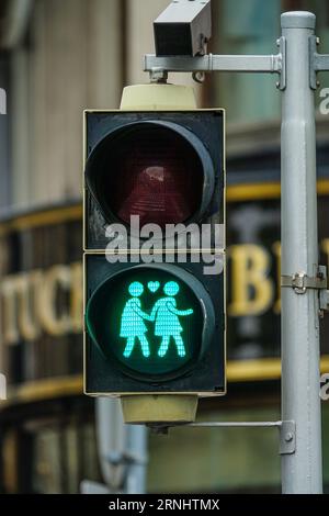 I semafori pedonali di Vienna sono incantevoli e la coppia si tiene per mano con amore, il semaforo è verde. Foto Stock