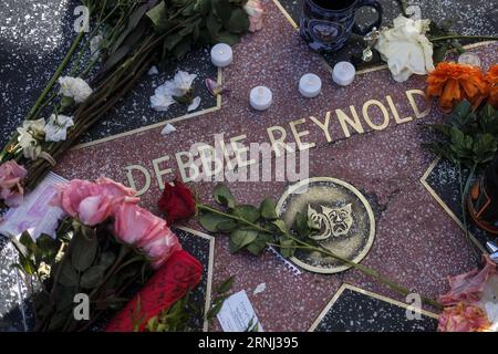 LOS ANGELES, 29 dicembre 2016 - Fiori e candele circondano la stella della Hollywood Walk of Fame di Debbie Reynolds, a Los Angeles, California, Stati Uniti, il 29 dicembre, 2016. la star di Hollywood Debbie Reynolds è morta di ictus mercoledì all'età di 84 anni, un giorno dopo la morte di sua figlia Carrie Fisher. Carrie Fisher, l'attrice meglio conosciuta come Princess Leia nel franchise di Star Wars, è morta all'età di 60 anni martedì mattina, dopo aver subito un attacco di cuore su un volo venerdì scorso. ) (ZW) U.S.-LOS ANGELES-DEBBIE REYNOLDS-CARRIE FISHER-WALK OF FAME-CONDOGLIENCE ZHAOXHANRONG PUBLICATIONXNOTXINXCHN Foto Stock