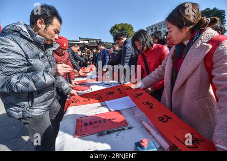 (170120) -- HANGZHOU, 20 gennaio 2017 -- le persone locali e i turisti ricevono distici e manifesti del Festival di Primavera scritti da calligrafi nella città di Tangqi, a Hangzhou, nella provincia dello Zhejiang nella Cina orientale, 20 gennaio 2017. Xiaonian, il 23° giorno del 12° mese del calendario lunare tradizionale cinese, cade il 20 gennaio di quest'anno. La gente del posto e i turisti accolgono il prossimo Capodanno lunare scrivendo distici del Festival di Primavera e preparando piatti tradizionali, tra cui torte di riso, riso appiccicoso alla zucca e sculture di riso. ) (kn) CHINA-HANGZHOU-SPRING FESTIVAL-TRADITIONAL FOOD (CN) XuxYu PUBLICATIONxNOTxINxCHN Foto Stock