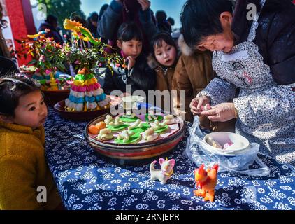 (170120) -- HANGZHOU, 20 gennaio 2017 -- la gente guarda il processo di produzione delle sculture tradizionali di riso nella città di Tangqi, a Hangzhou, nella provincia dello Zhejiang nella Cina orientale, 20 gennaio 2017. Xiaonian, il 23° giorno del 12° mese del calendario lunare tradizionale cinese, cade il 20 gennaio di quest'anno. La gente del posto e i turisti accolgono il prossimo Capodanno lunare scrivendo distici del Festival di Primavera e preparando piatti tradizionali, tra cui torte di riso, riso appiccicoso alla zucca e sculture di riso. ) (kn) CHINA-HANGZHOU-SPRING FESTIVAL-TRADITIONAL FOOD (CN) XuxYu PUBLICATIONxNOTxINxCHN Hangzhou Jan 20 2017 Celeb Foto Stock