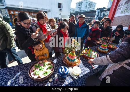 (170120) -- HANGZHOU, 20 gennaio 2017 -- i turisti vedono le sculture tradizionali di riso nella città di Tangqi di Hangzhou, nella provincia dello Zhejiang, nella Cina orientale, 20 gennaio 2017. Xiaonian, il 23° giorno del 12° mese del calendario lunare tradizionale cinese, cade il 20 gennaio di quest'anno. La gente del posto e i turisti accolgono il prossimo Capodanno lunare scrivendo distici del Festival di Primavera e preparando piatti tradizionali, tra cui torte di riso, riso appiccicoso alla zucca e sculture di riso. ) (kn) CHINA-HANGZHOU-SPRING FESTIVAL-TRADITIONAL FOOD (CN) XuxYu PUBLICATIONxNOTxINxCHN Hangzhou Jan 20 2017 turisti Visualizza Traditional R Foto Stock