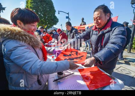 (170120) -- HANGZHOU, 20 gennaio 2017 -- le persone locali e i turisti ricevono distici e manifesti del Festival di Primavera scritti da calligrafi nella città di Tangqi, a Hangzhou, nella provincia dello Zhejiang nella Cina orientale, 20 gennaio 2017. Xiaonian, il 23° giorno del 12° mese del calendario lunare tradizionale cinese, cade il 20 gennaio di quest'anno. La gente del posto e i turisti accolgono il prossimo Capodanno lunare scrivendo distici del Festival di Primavera e preparando piatti tradizionali, tra cui torte di riso, riso appiccicoso alla zucca e sculture di riso. ) (kn) CHINA-HANGZHOU-SPRING FESTIVAL-TRADITIONAL FOOD (CN) XuxYu PUBLICATIONxNOTxINxCHN Foto Stock