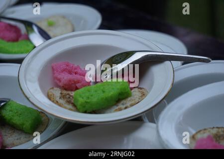 Dawet serabi per gli acquirenti in un mercato tradizionale. È il tradizionale cibo giavanese di filamenti di farina di riso arricciati in una palla; mangiato con latte di cocco A. Foto Stock