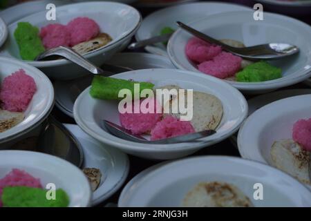 Dawet serabi per gli acquirenti in un mercato tradizionale. È il tradizionale cibo giavanese di filamenti di farina di riso arricciati in una palla; mangiato con latte di cocco A. Foto Stock