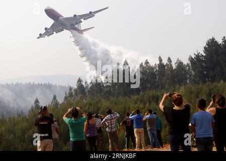 (170201) -- detto, 1 febbraio 2017 -- la gente guarda come l'aereo superpetroliera scarica l'acqua durante il combattimento di un incendio nella città di Dichato, Cile, il 31 gennaio 2017. Martedì il presidente cileno Michelle Bachelet ha detto che il suo governo farà tutti gli sforzi per avviare il processo di ricostruzione e recupero dopo gli enormi incendi boschivi nel paese. ) (ma) (da) CHILE-DICHATO-FOREST FIRE MarioxDavila/AGENCIAUNO PUBLICATIONxNOTxINxCHN DICHATO Feb 1 2017 Celebrities Watch as the Super Tankers Plane UNLOAD Water during the Combat of a Wild in the Town of DICHATO Chile ON Jan 31 2017 Foto Stock