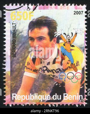 BENIN - CIRCA 2007: Timbro stampato dal Benin, mostra Bernard Hinault, Disney Caharacter e Olympic Rings, circa 2007 Foto Stock