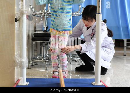 (170421) -- URUMQI, 21 aprile 2017 -- terapista riabilitativo min Xiaojuan (R) aiuta una delle ragazze gemelle con formazione di riabilitazione delle gambe presso il Six Affiliated Hospital dell'Università medica dello Xinjiang a Urumqi, capitale della regione autonoma dello Xinjiang Uygur della Cina nord-occidentale, 17 aprile 2017. I gemelli di sei anni dell'Uzbekistan hanno diagnosticato paralisi cerebrale, quando sono arrivati in Cina nel novembre 2016, entrambi non possono camminare in modo indipendente ed esprimere chiaramente. Dopo essere stati trattati con agopuntura, massaggio terapeutico, erboristeria e terapia riabilitativa, i gemelli potevano camminare in modo indipendente Foto Stock