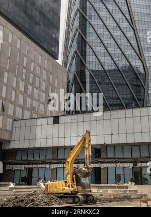 Bangkok, Thailandia - 31 agosto 2023 - Un escavatore edile di colore giallo è parcheggiato di fronte al cantiere edile. Livellatrice ed escavatore Foto Stock