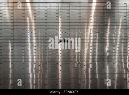 Cassette di sicurezza all'interno della cassaforte della banca con porte chiuse in acciaio. Armadietti in metallo, cassetta di sicurezza aperta con chiave, spazio per testo, messa a fuoco selettiva. Foto Stock