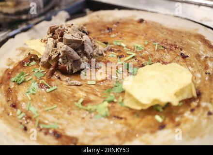 (170425) -- NEW YORK, 25 aprile 2017 -- A Jianbing of the Flavour of Roasted Duck is made at the kiosk of Mr. Bing in UrbanSpace food Court a New York, Stati Uniti, 17 aprile 2017. UrbanSpace nel centro di New York è un luogo dove i collari bianchi vengono a pranzo durante i loro giorni lavorativi. Negli ultimi mesi, i clienti si sono sempre allineati prima di un chiosco sotto uno striscione con caratteri cinesi. Quello che questo chiosco vende è un autentico cibo cinese nel nord della Cina -- Jianbing, o crepe cinese. Il chiosco è marchiato Mr. Bing ed è di proprietà di Brian Goldberg, che è nato e cresciuto a New York. G Foto Stock