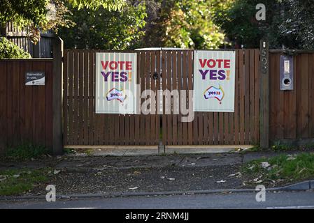 Due segnali gialli di voto sì su un cancello di legno nella periferia di Melbourne, parte della campagna indigena per il referendum del parlamento Foto Stock