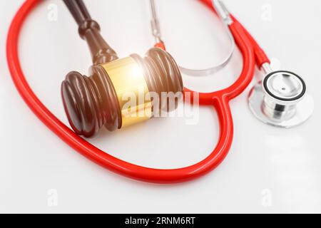 Il martello giudice con stetoscopio per la professione medica medico relazionano con il concetto di immagine del contenzioso giudiziario Foto Stock