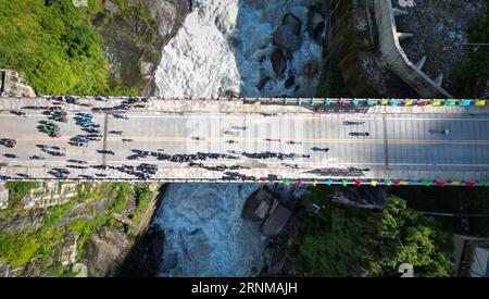 (230902) -- XIGAZE, 2 settembre 2023 (Xinhua) -- questa foto aerea scattata il 1 settembre 2023 mostra i passeggeri cinesi e nepalesi che camminano attraverso il ponte dell'amicizia Cina-Nepal al porto di Zham a Xigaze, nella regione autonoma Tibet della Cina sud-occidentale. Il porto di Zham, nella regione autonoma del Tibet della Cina sud-occidentale, un importante porto terrestre tra la Cina e il Nepal, ha ripreso il traffico passeggeri a due vie venerdì dopo essere stato chiuso per otto anni. Secondo le autorità locali, 752 persone hanno attraversato il confine durante il primo giorno della ripresa. I giornalisti di Xinhua hanno visto lunghe code all'uscita e all'ingresso della reception Foto Stock