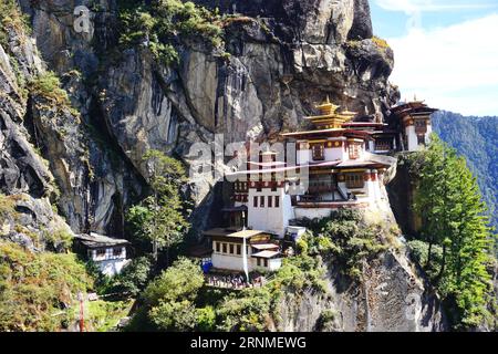 Vista del complesso del Monastero del Nido delle Tigri arroccato su una serie di strette scogliere alte sulle montagne sopra la valle di Paro nel regno del Bhutan Foto Stock