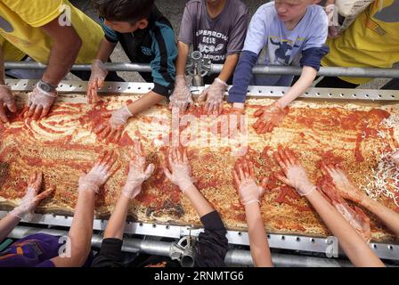 (170611) -- LOS ANGELES, 11 giugno 2017 -- i volontari lavorano su una pizza mentre hanno infranto il Guinness World Records titolo per la pizza più lunga con una lunghezza di 1,32 miglia (2,13 chilometri) a Fontana, The United Staes, 10 giugno 2017. L'ultima pizza più lunga misurava 1.853,88 metri ed è stata realizzata dal Napoli Pizza Village, a Napoli, Italia, 18 maggio 2016. ) (gj) U.S.-LOS ANGELES-LONGEST PIZZA ZhaoxHanrong PUBLICATIONxNOTxINxCHN 170611 Los Angeles 11 giugno 2017 i volontari lavorano SU una pizza mentre hanno infranto il Guinness World Records Title per la pizza PIÙ LUNGA con una lunghezza di 1 32 miglia 2 13 chilometri i Foto Stock