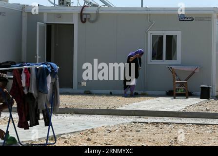 (170617) -- SERRES, 17 giugno 2017 -- Una donna pulisce il cortile di fronte al suo container di casa nel campo profughi aperto di Serres, Grecia, il 7 giugno 2017. Alla periferia di Serres, una città di circa 80.000 persone, circa 600 chilometri a nord di Atene, file ordinate di container prefabbricati trasformati in case a due camere da letto forniscono rifugio per 350 yazidi. GRECIA-SERRES-REFUGEE MariosxLolos PUBLICATIONxNOTxINxCHN Serres 17 giugno 2017 una donna pulisce lo Yard di fronte al suo container Home nel Serres Open Refugee Camp Grecia IL 7 giugno 2017 ALLA periferia di Serres una città di circa 80 000 Celebr Foto Stock