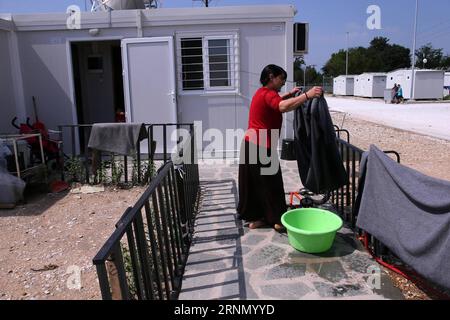 (170617) -- SERRES, 17 giugno 2017 -- Una donna impicca una coperta davanti alla sua unità abitativa container nel campo profughi aperto di Serres, Grecia, il 7 giugno 2017. Alla periferia di Serres, una città di circa 80.000 persone, circa 600 chilometri a nord di Atene, file ordinate di container prefabbricati trasformati in case a due camere da letto forniscono rifugio per 350 yazidi. GRECIA-SERRES-REFUGEE MariosxLolos PUBLICATIONxNOTxINxCHN Serres 17 giugno 2017 una donna impicca una coperta di fronte alla sua unità di alloggio container nel campo profughi aperto di Serres in Grecia IL 7 giugno 2017, ALLA periferia di Serres, una città di Abo Foto Stock