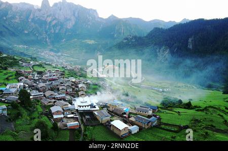 (170621) -- DIEBU, 21 giugno 2017 -- foto scattata il 21 giugno 2017 mostra un villaggio sulle montagne Zhagana nella contea di Diebu, prefettura autonoma tibetana di Gannan, provincia del Gansu della Cina nord-occidentale. Zhagana è una regione montuosa sul bordo nord-orientale dell'altopiano tibetano, con un'altitudine media di 3.500 metri. La regione ha un paesaggio culturale e naturale unico con villaggi in stile tibetano, foreste primitive e montagne. ) (wyo) CHINA-GANSU-ZHAGANA-LANDSCAPE-MOUNTAIN LANDSCAPE (CN) ChenxBin PUBLICATIONxNOTxINxCHN Diebu 21 giugno 2017 foto scattata IL 21 giugno 2017 mostra un villaggio SU T Foto Stock