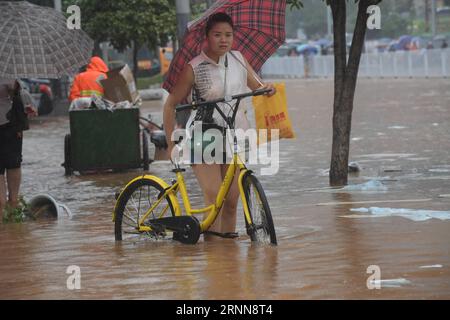 (170701) - CHANGSHA, 1 luglio 2017 - Una donna cammina con una bicicletta su una strada allagata a Changsha, capitale della provincia di Hunan della Cina centrale, 1 luglio 2017. Più di 260.000 persone sono state sfollate dopo continue piogge pesanti che hanno colpito la provincia centrale di Hunan della Cina dal 22 giugno, ha detto l'ufficio provinciale di controllo delle inondazioni venerdì. ) (Zwx) CHINA-CHANGSHA-RAINSTORM (CN) LongxHongtao PUBLICATIONxNOTxINxCHN Changsha 1 luglio 2017 una donna cammina con una bici SU una strada allagata a Changsha capitale della provincia di Hunan della Cina centrale 1 luglio 2017 più di 260 000 celebrità sono state sfollate dopo il continuo Foto Stock