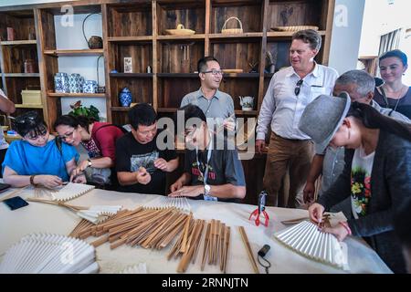 (170718) -- ANJI, 18 luglio 2017 -- gli esperti del turismo sperimentano la creazione di fan nella città di Zhangwu della contea di Anji, nella provincia di Zhejiang nella Cina orientale, 18 luglio 2017. Dozzine di esperti del turismo che hanno partecipato a un convegno internazionale sul turismo rurale hanno visitato la città di Zhangwu martedì. Circa 400 esperti provenienti da oltre 10 paesi e regioni hanno partecipato alla convention turistica di Anji lunedì e martedì. ) (mcg) CHINA-ZHEJIANG-ANJI-TOURISM (CN) XuxYu PUBLICATIONxNOTxINxCHN Anji 18 luglio 2017 esperti del turismo esperienza tifosi nella città di Zhangwu della contea di Anji nella provincia di Zhejiang della Cina orientale 18 luglio Foto Stock