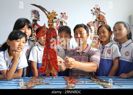 (170726) -- HANDAN, 26 luglio 2017 -- l'artista del gioco d'ombra Zhang Yingfeng spiega la conoscenza del gioco d'ombra per i bambini lasciati dietro, a Handan City, nella provincia di Hebei, nella Cina settentrionale, 26 luglio 2017. Il gioco d'ombra è il patrimonio culturale immateriale della Cina. La scuola elementare Jiudian del distretto di Feixiang a Handan City ha iniziato gratuitamente una lezione di gioco d'ombra, che arricchisce la vita estiva dei bambini. ) (lxx) CHINA-HEBEI-SHADOW PLAY-SUMMER VACATION(CN) MuxYu PUBLICATIONxNOTxINxCHN Handan luglio 26 2017 l'artista Shadow Play Zhang spiega la conoscenza del gioco Shadow per Left Behind Children in Handan City N. Foto Stock