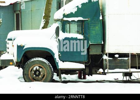 Auto d'epoca Rusty. Vecchio cassone arrugginito. Auto abbandonata. auto coperta di neve Foto Stock