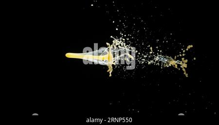 Il succo d'arancia esplode e spruzza su sfondo nero Foto Stock