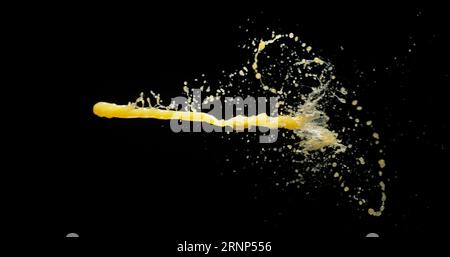 Il succo d'arancia esplode e spruzza su sfondo nero Foto Stock