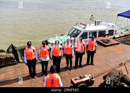 (170811) -- ANQING, 11 agosto 2017 -- i pattugliatori ausiliari si mettono in fila prima di iniziare a pattugliare nella riserva naturale di foschia fina ad Anqing, nella provincia di Anhui nella Cina orientale, 10 agosto 2017. Una brigata ausiliaria di pattuglia, tra cui 6 ex pescatori, ha iniziato la sua missione nel giugno 2017 proteggendo le 60 focene senza alette lungo la sezione lunga 60 chilometri del fiume Yangtze nella provincia. L'applicazione telefonica viene utilizzata nelle loro missioni di routine per monitorare e osservare la vita dei mammiferi simili a delfini, fornire la necessaria protezione e monitorare la pesca illegale e inquinante nella riserva. ) (clq) CHI Foto Stock