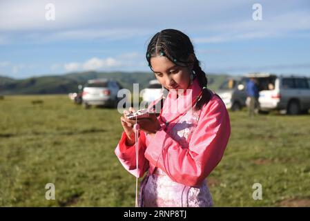 (170816) -- XIAHE, 16 agosto 2017 -- Deqen Yuzhen ascolta i messaggi con il suo cellulare sulla prateria della sua città natale, Contea di Maqu, Prefettura autonoma tibetana di Gannan, provincia del Gansu della Cina nord-occidentale, 13 agosto 2017. Deqen Yuzhen, nata il 14 settembre 1998, è la figlia di una famiglia di pastori nella contea di Maqu, prefettura autonoma tibetana di Gannan, provincia del Gansu nella Cina nordoccidentale. Sfortunatamente ha perso la vista a causa di una grave malattia quando era piccola. All'età di nove anni fu mandata alla scuola per bambini ciechi nella regione Autonoma del Tibet nel sud-ovest della Cina e trasferita a blino Foto Stock